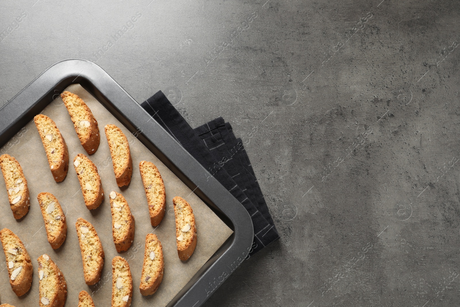 Photo of Traditional Italian almond biscuits (Cantucci) on grey table, top view. Space for text