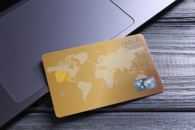 Credit card and laptop on grey wooden table