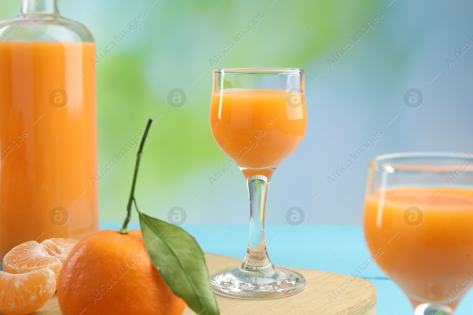 Photo of Delicious tangerine liqueur and fresh fruits on table