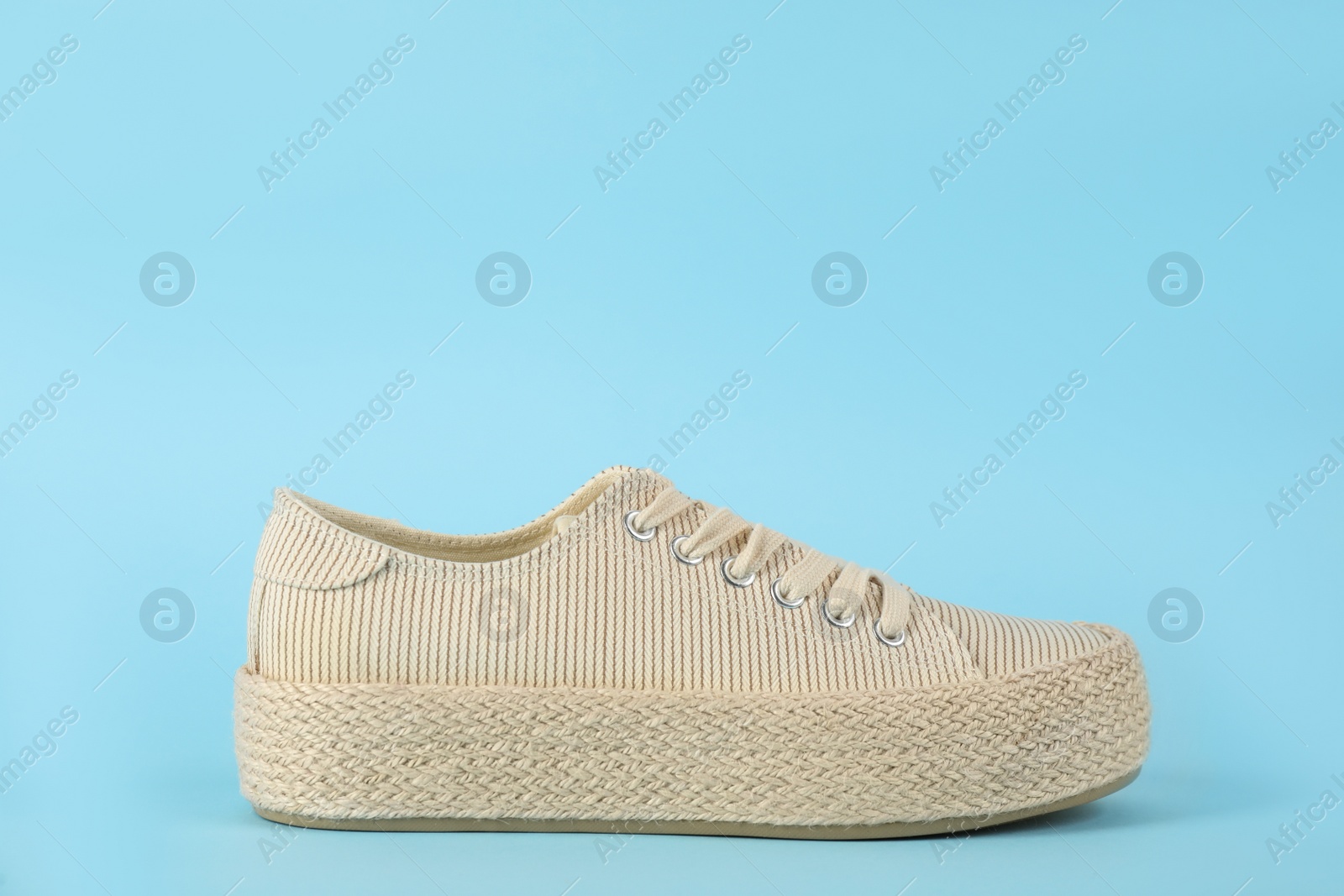 Photo of Stylish comfortable shoe on light blue background. Space for text