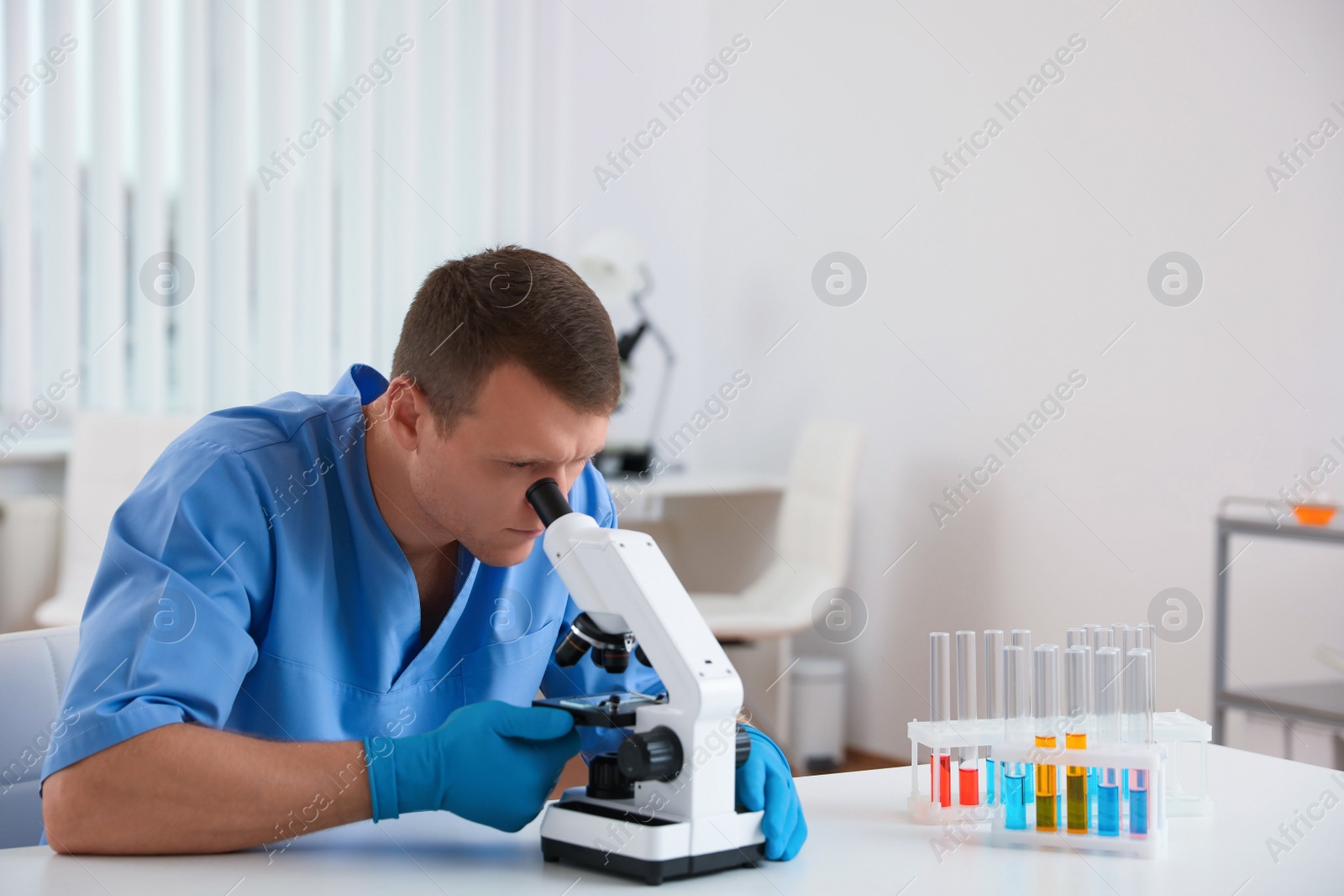 Photo of Scientist using modern microscope at table. Medical research