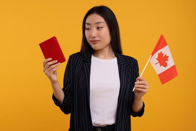 Immigration to Canada. Woman with passport and flag on orange background