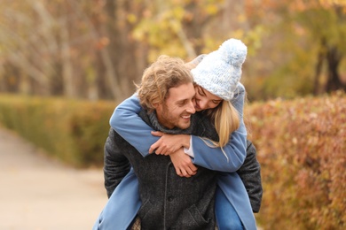 Photo of Young romantic couple having fun in park on autumn day