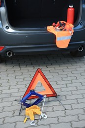 Photo of Emergency warning triangle and safety equipment near car