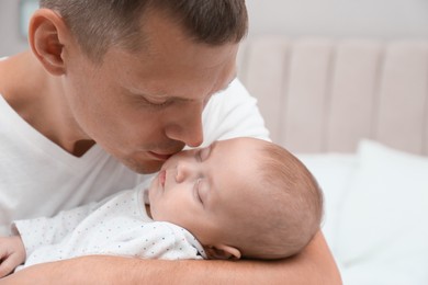 Father holding his cute sleeping baby at home, closeup