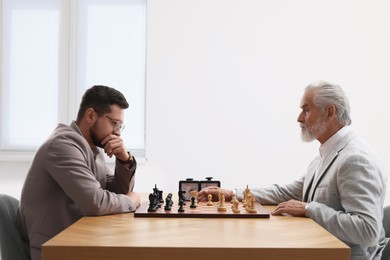 Men playing chess during tournament at table indoors
