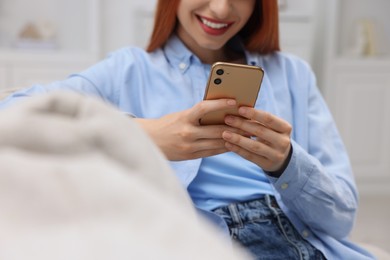 Photo of Woman sending message via smartphone indoors, closeup