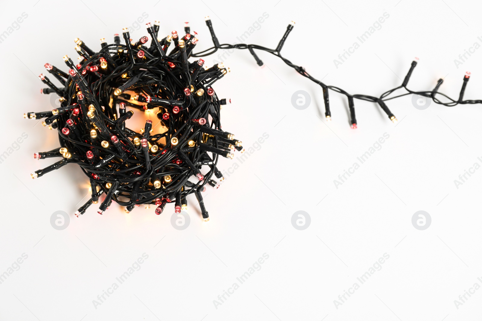 Photo of Beautiful Christmas lights on white background, top view