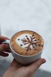 Photo of Woman with cuparomatic coffee outdoors in winter, closeup