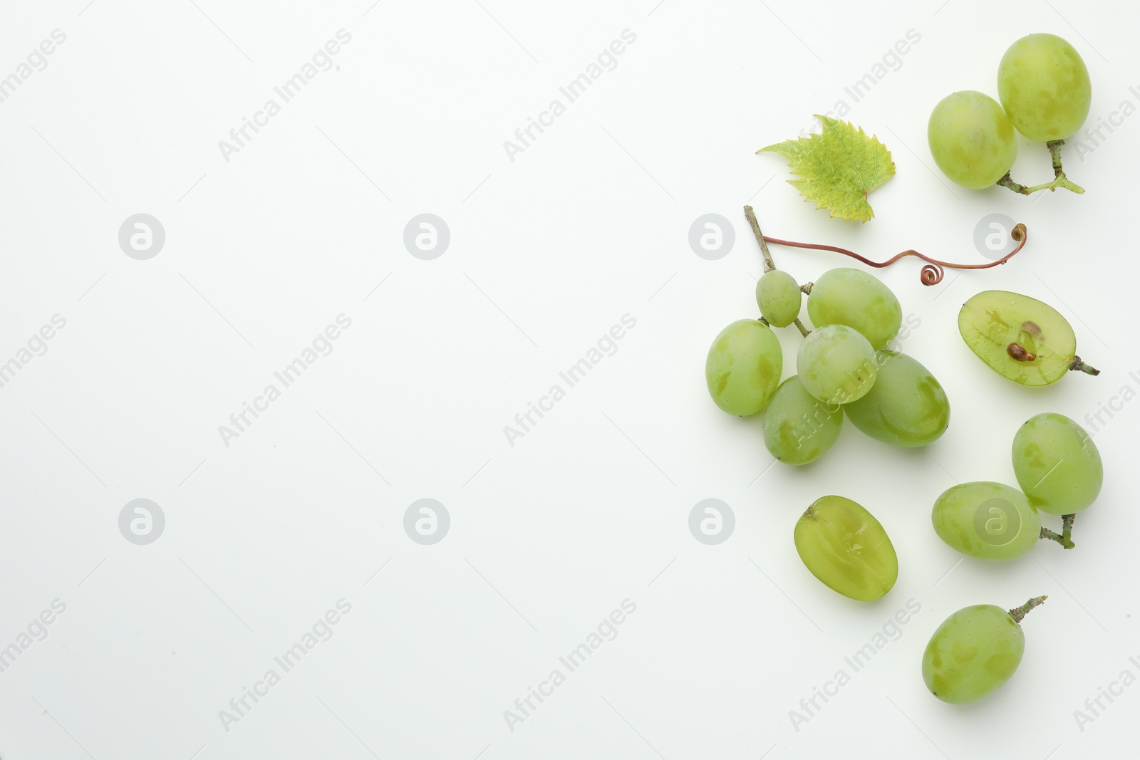 Photo of Fresh grapes and leaf on white background, top view. Space for text