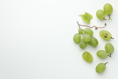Fresh grapes and leaf on white background, top view. Space for text