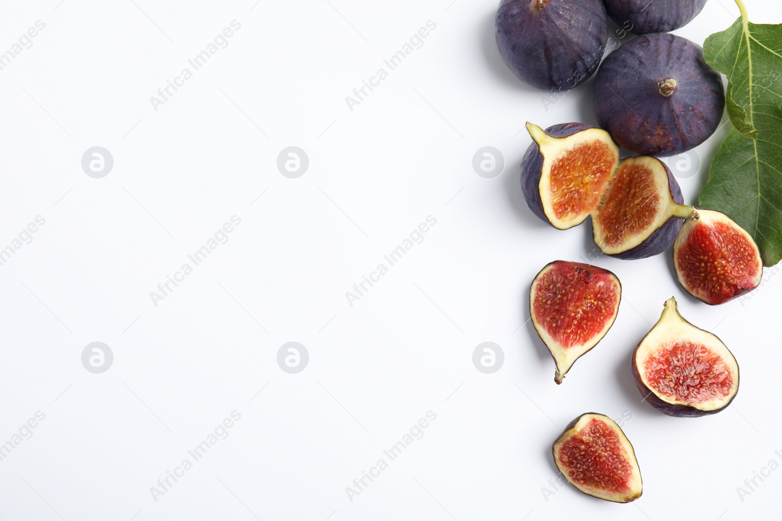 Photo of Delicious ripe figs with green leaf on white background, top view