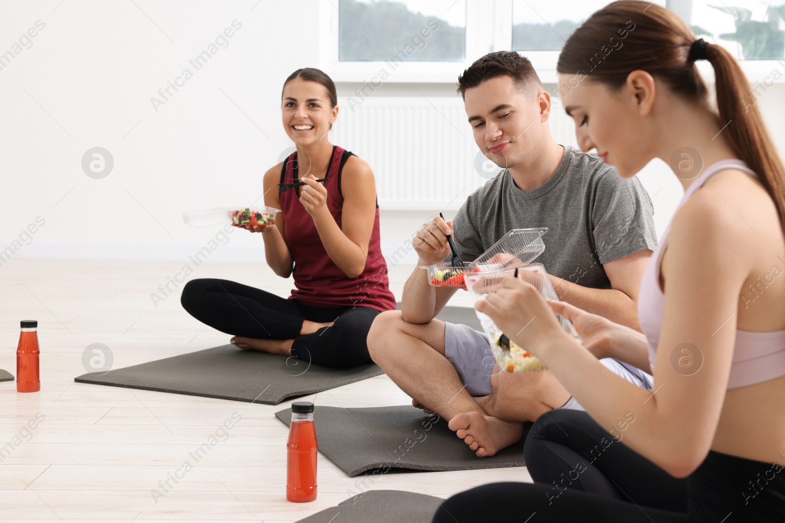 Photo of Group of people eating healthy food after yoga class indoors