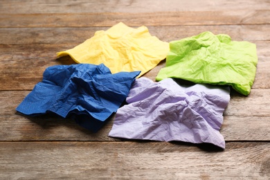 Photo of Crumpled paper napkins on wooden background. Personal hygiene