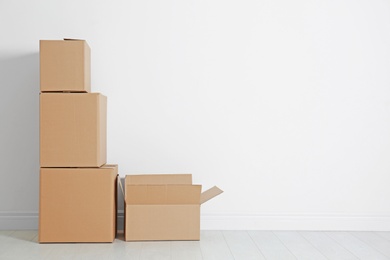 Photo of Cardboard boxes on floor near white wall