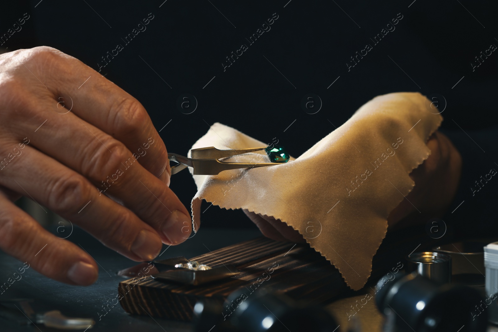 Photo of Professional jeweler working with gemstone at table, closeup