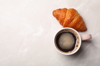 Photo of Cup of coffee and croissant on light background, flat lay. Space for text