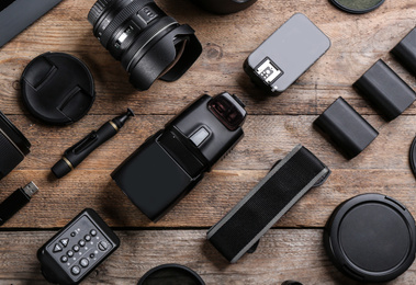 Photo of Flat lay composition with equipment for professional photographer on wooden table