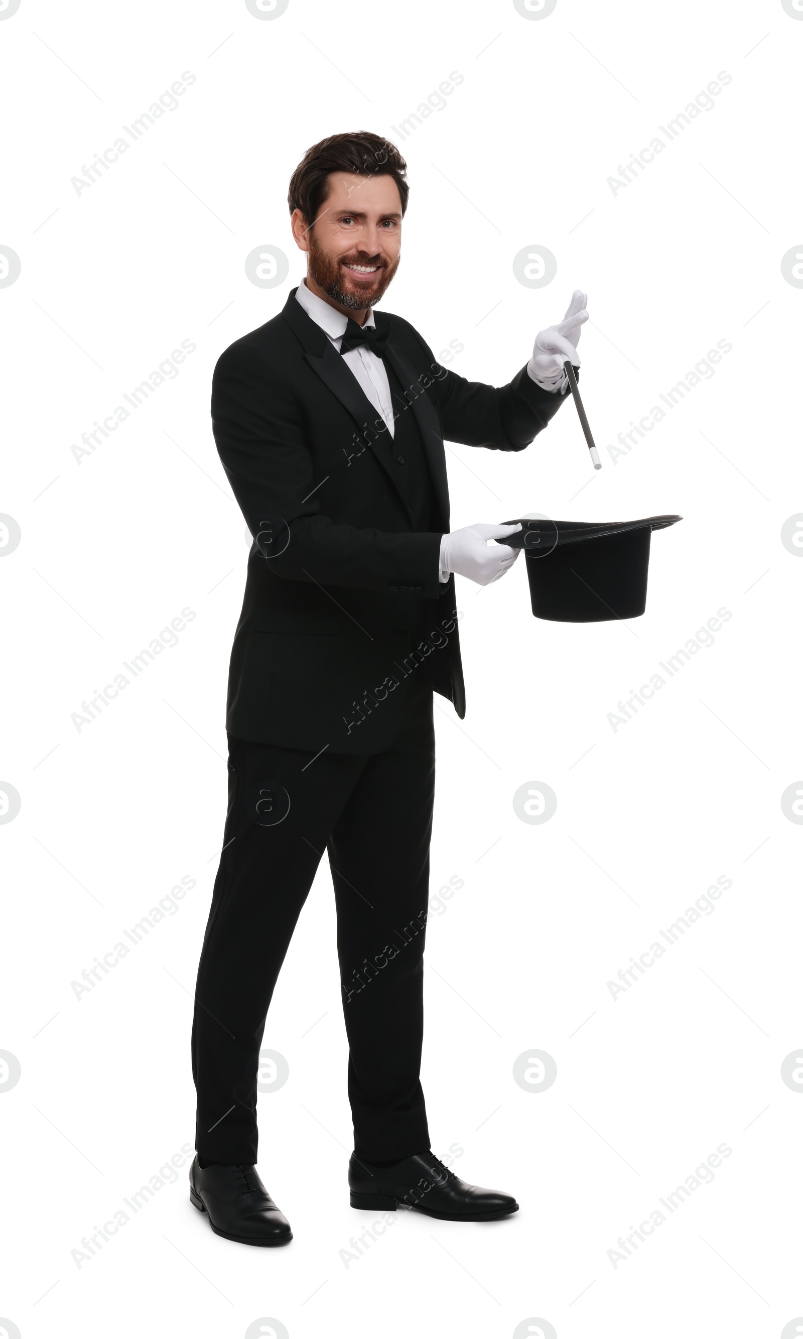 Photo of Happy magician showing magic trick with top hat on white background