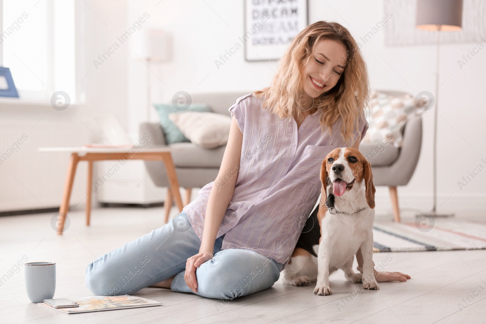 Photo of Young woman with her dog at home