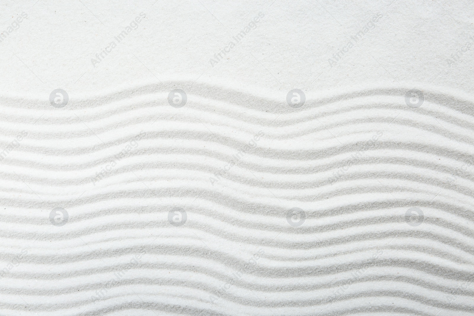 Photo of Zen rock garden. Wave pattern on white sand, top view