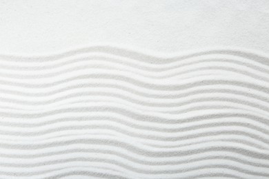 Photo of Zen rock garden. Wave pattern on white sand, top view