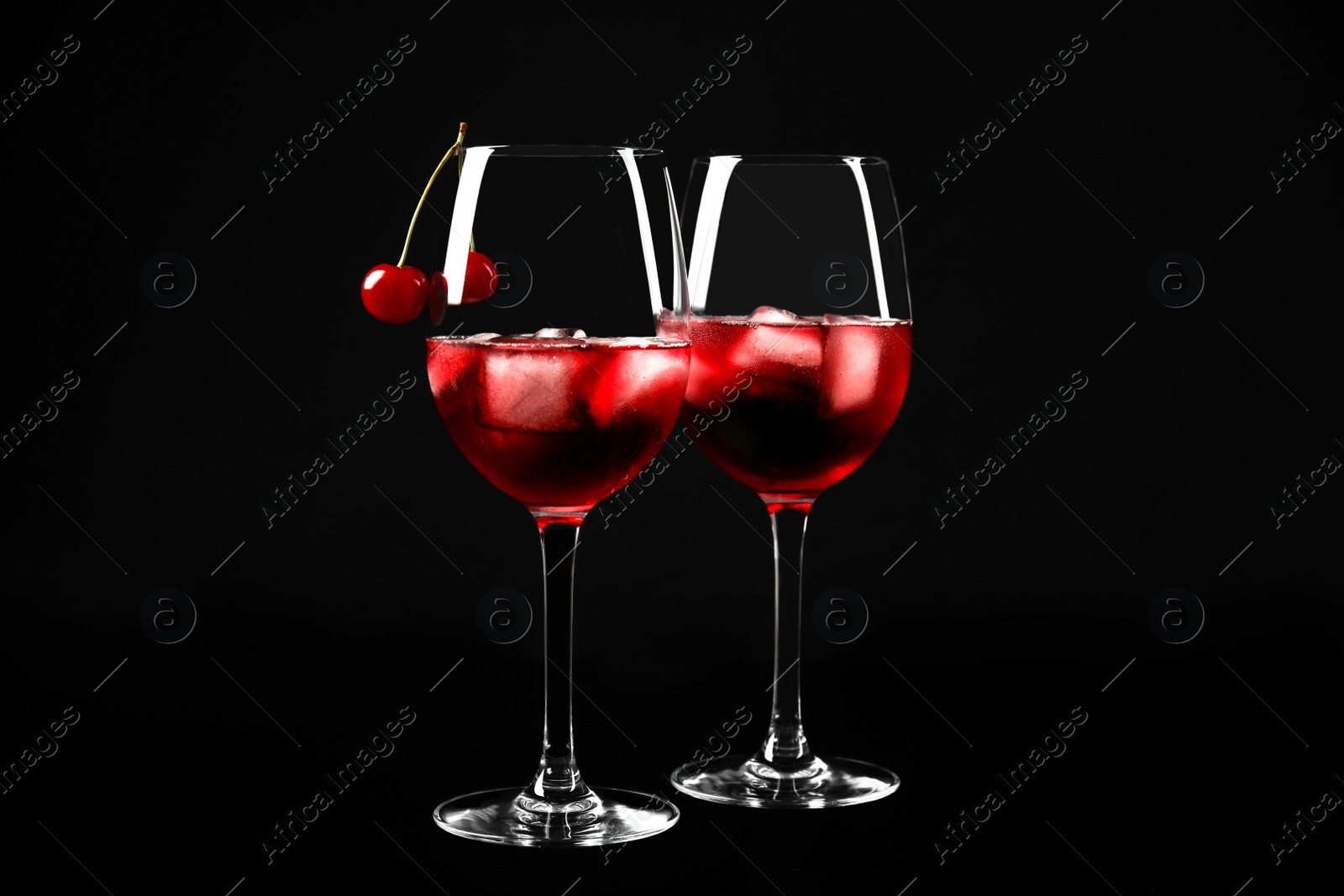 Photo of Delicious cherry wine with ripe juicy berries on black background