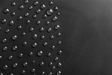 Photo of Water drops on black background, top view. Space for text
