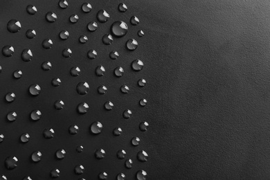 Water drops on black background, top view. Space for text