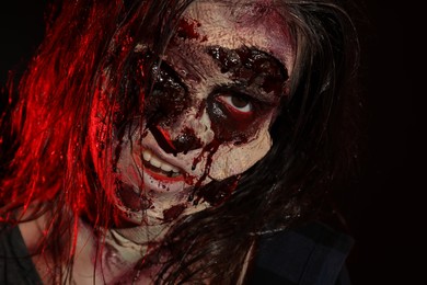 Photo of Scary zombie on dark background, closeup. Halloween monster