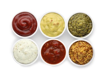 Many different sauces in bowls on white background, top view