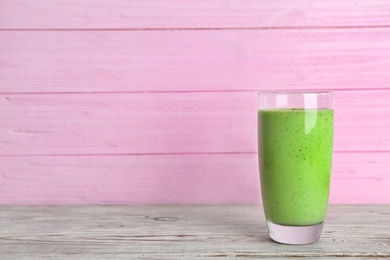 Photo of Glass with delicious detox smoothie on table