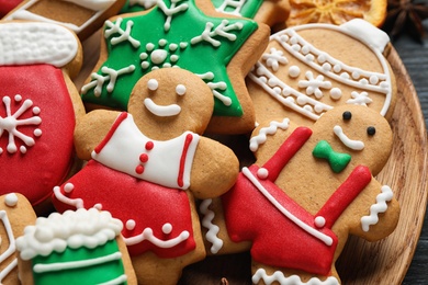 Photo of Tasty homemade Christmas cookies on wooden plate, closeup view