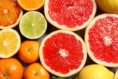 Photo of Different citrus fruits as background, top view