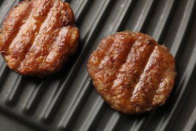 Photo of Delicious hamburger patties on electric grill, closeup
