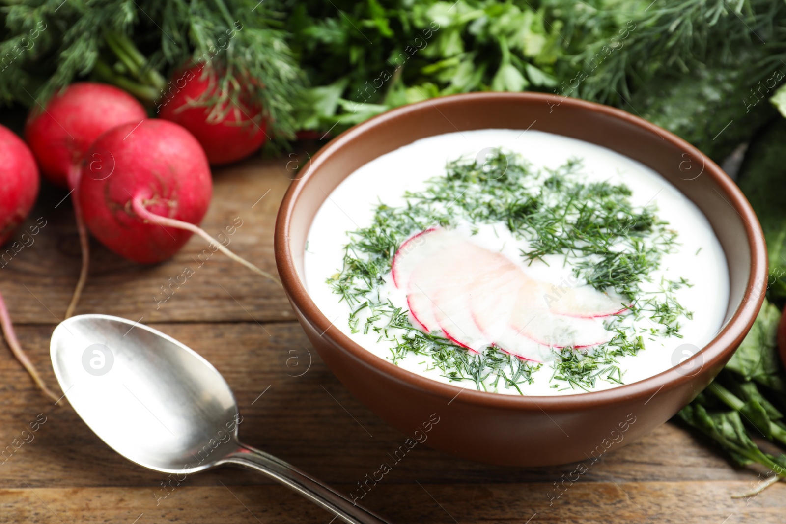 Photo of Delicious cold summer soup with kefir served on wooden table