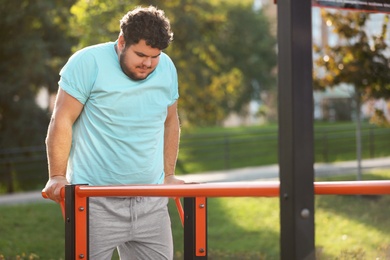 Photo of Young overweight man training on sports ground