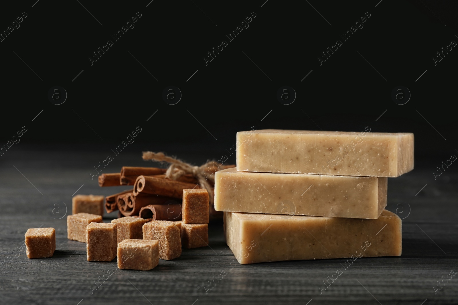 Photo of Handmade soap bars, brown sugar and cinnamon sticks on table