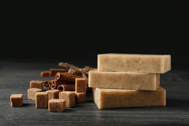 Handmade soap bars, brown sugar and cinnamon sticks on table