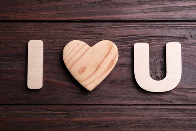 Phrase I Love You made of wooden letters and heart on table, flat lay