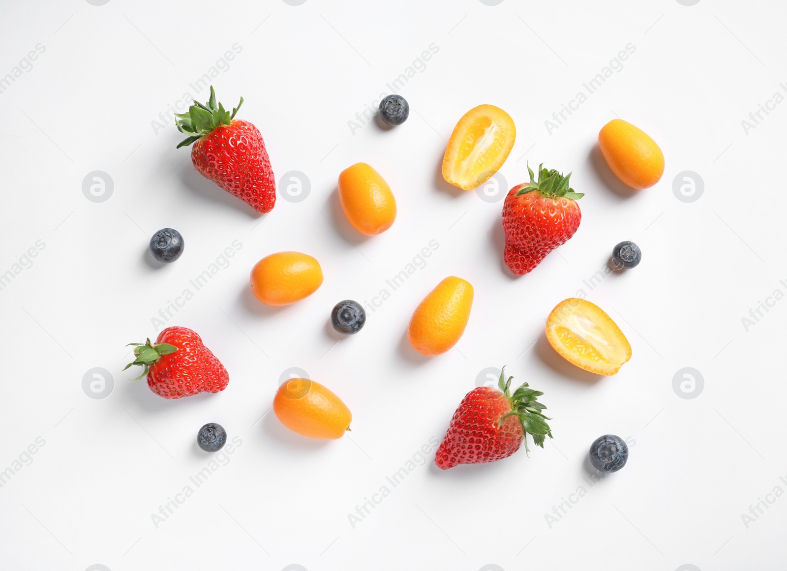 Photo of Fresh kumquats and berries on white background, top view