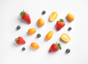 Fresh kumquats and berries on white background, top view