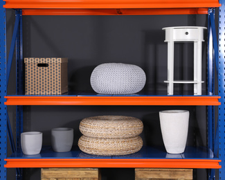 Photo of Metal shelving unit with different household stuff on black background