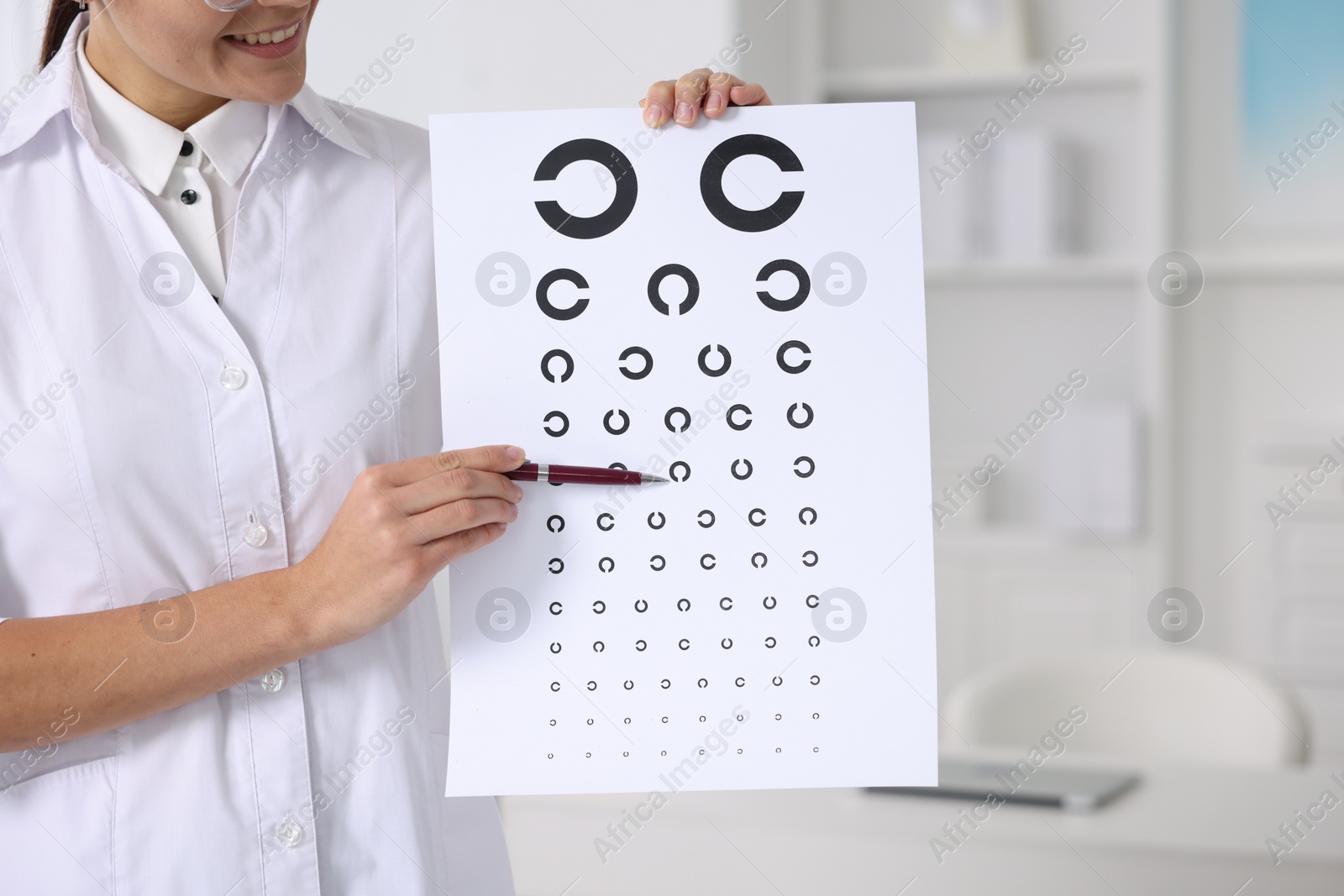 Photo of Ophthalmologist pointing at vision test chart in clinic, closeup