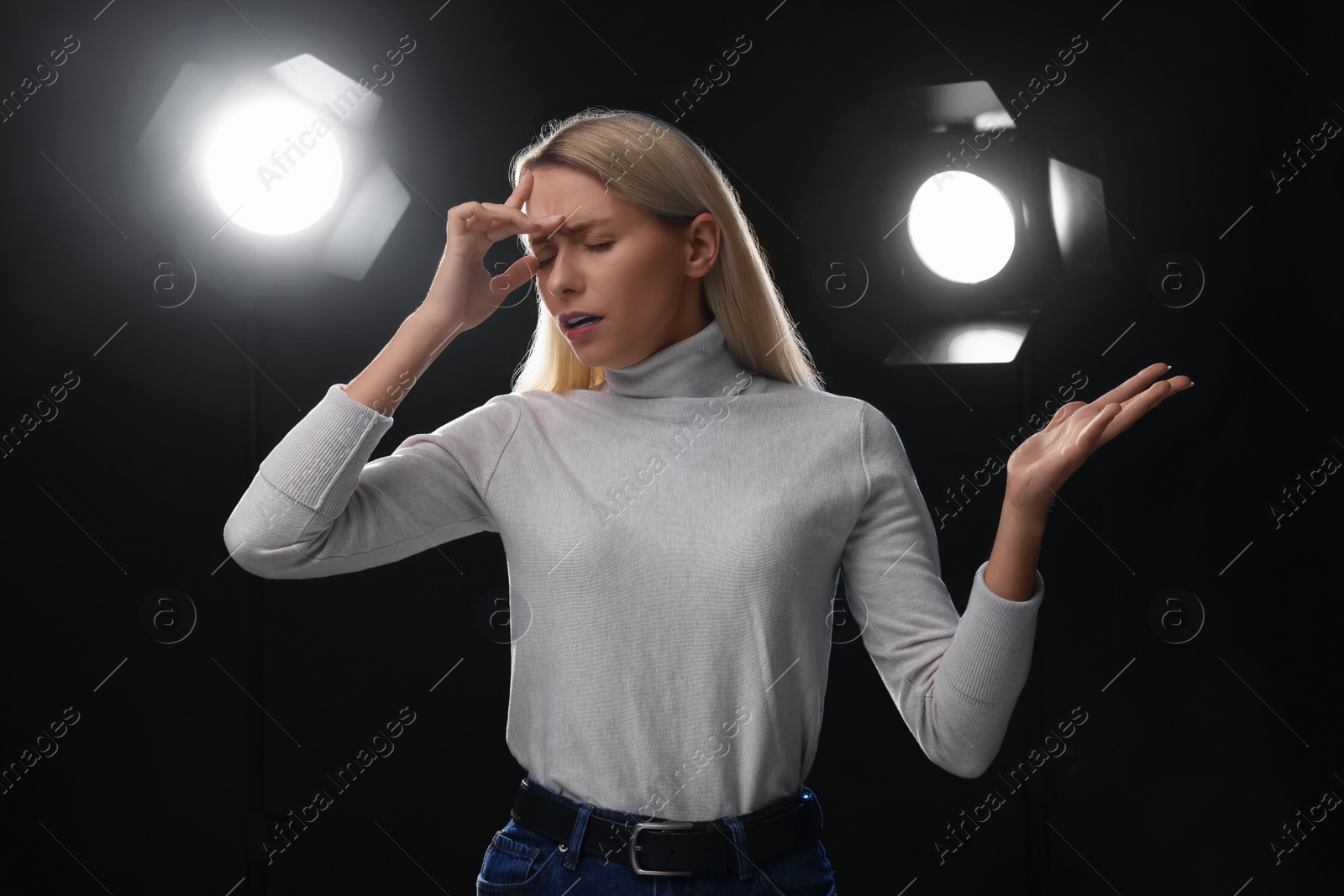 Photo of Casting call. Emotional woman performing on black background