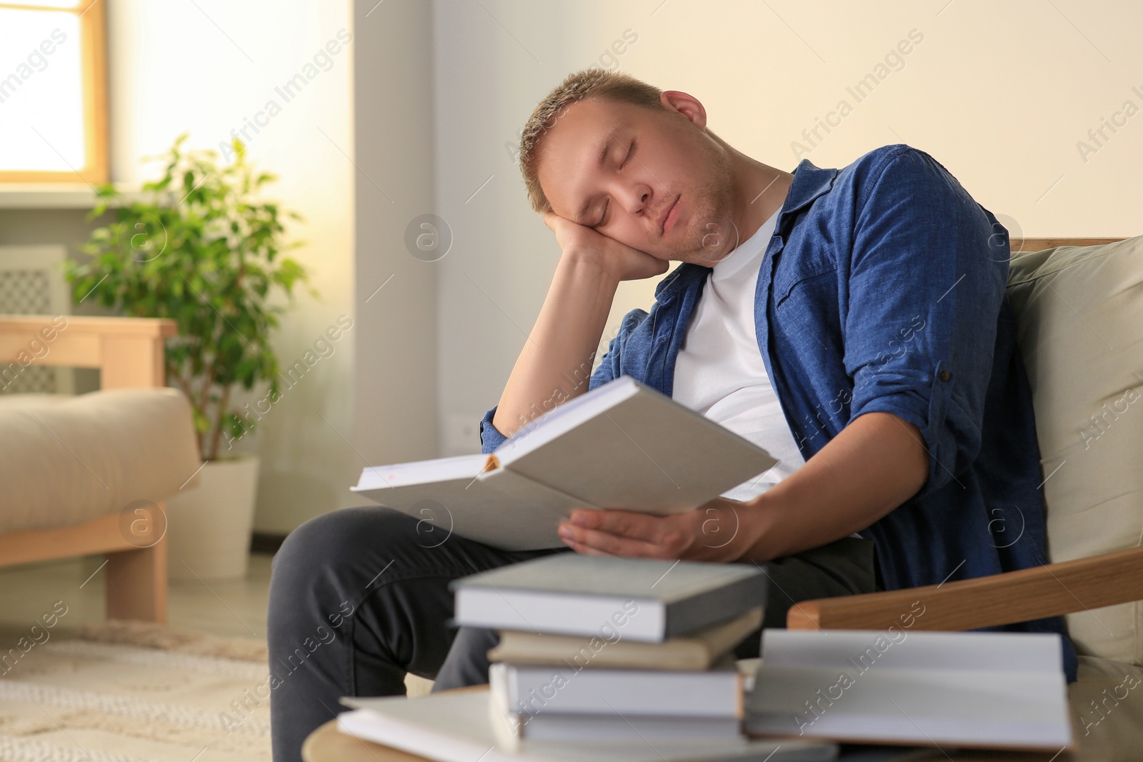 Photo of Tired man studying in armchair at home