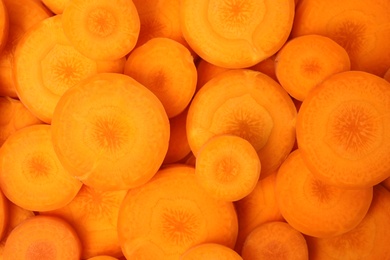 Photo of Slices of fresh ripe carrots as background, top view