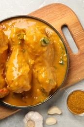 Photo of Tasty chicken curry and ingredients on grey textured table, flat lay