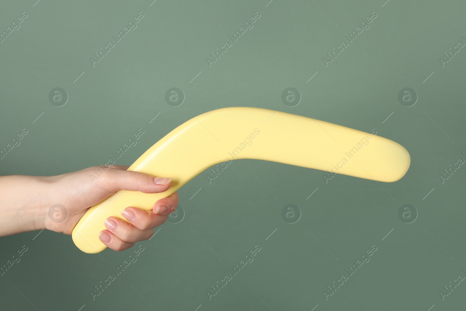 Photo of Woman holding boomerang on grey background, closeup