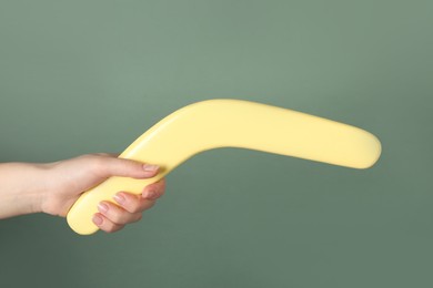 Woman holding boomerang on grey background, closeup